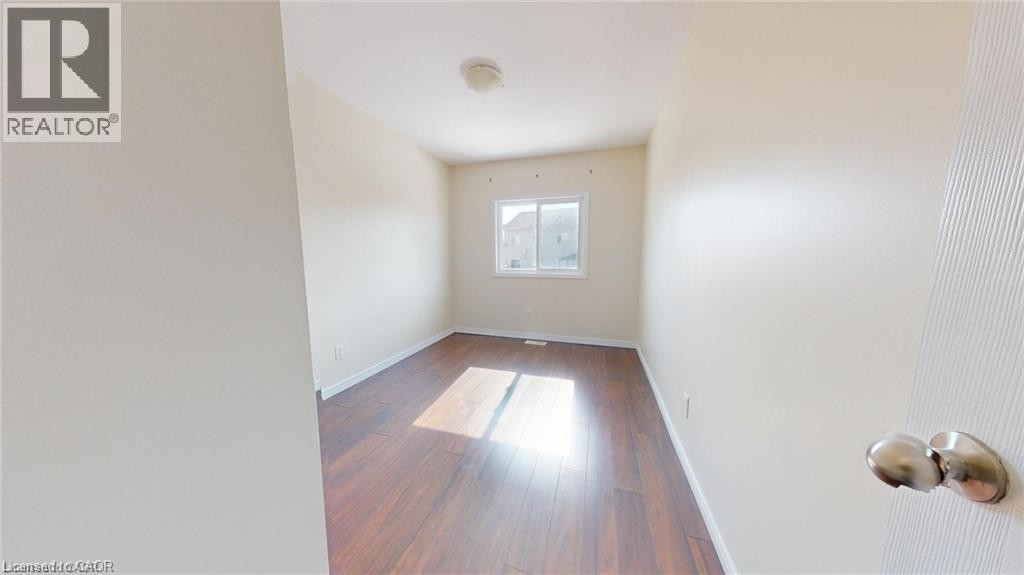 Wood-finish flooring, white walls, and a single window - 11 Sorrento Street, Kitchener, ON