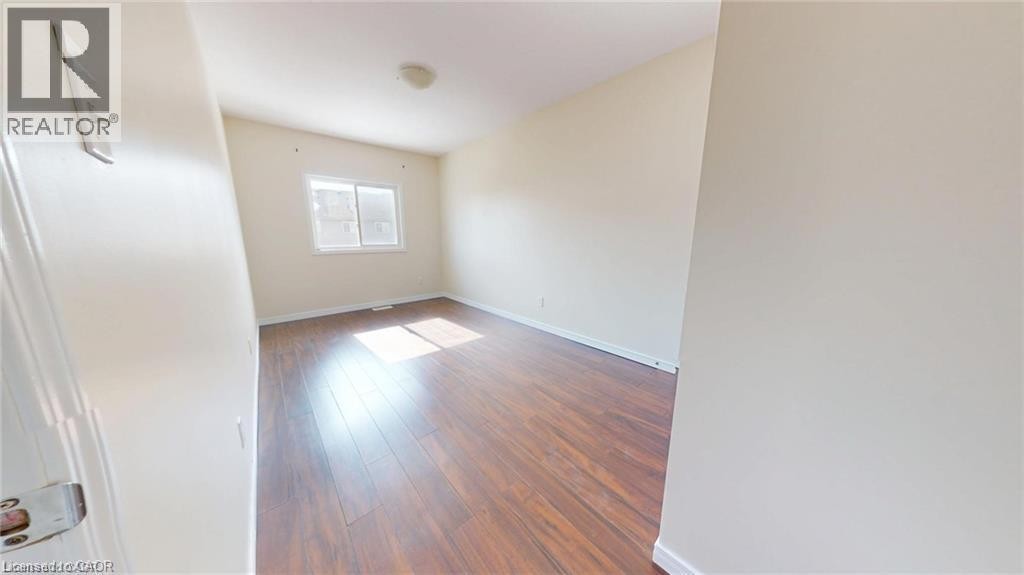 Wood-finish flooring, white walls, and a window with a white frame - 11 Sorrento Street, Kitchener, ON