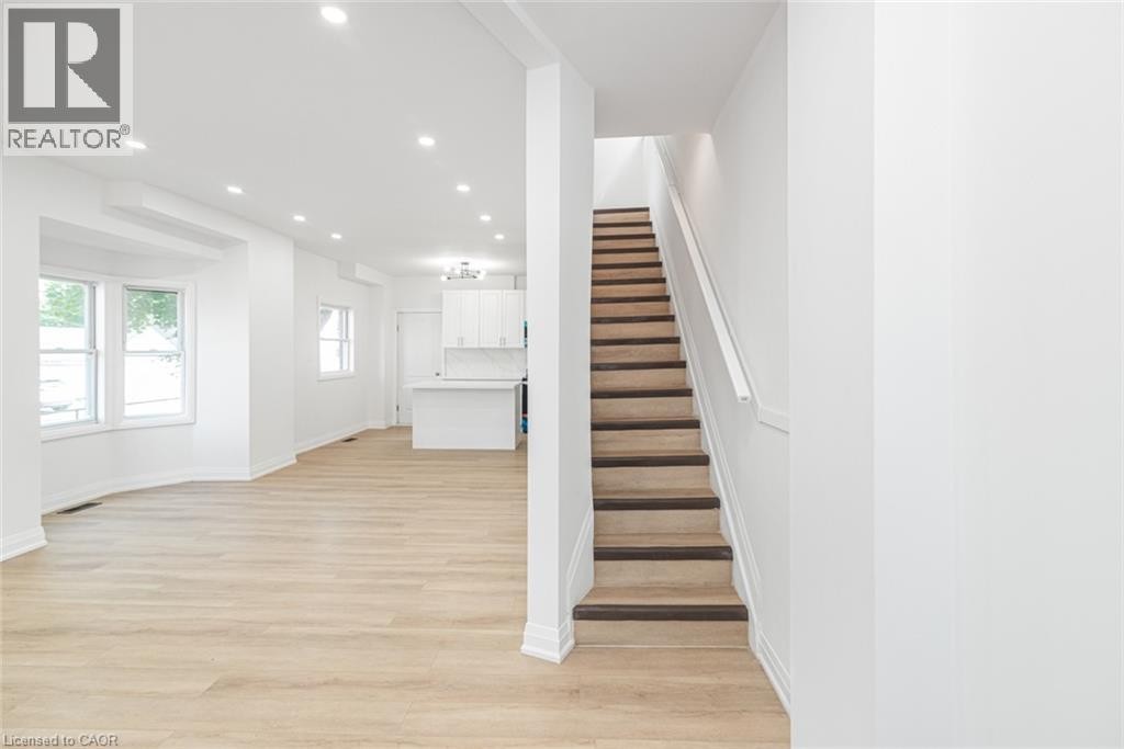 Light wood-finish flooring, recessed lighting, and a bay window - 90 Belview Avenue, Hamilton, ON