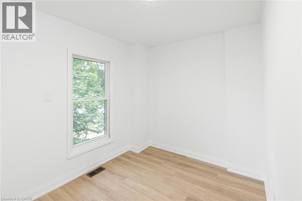 Recessed lighting, wood-finish flooring, white walls, and a single window with white trim - 90 Belview Avenue, Hamilton, ON