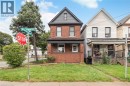 Brick exterior with a covered porch, dark trim accents, and a gabled roofline - 90 Belview Avenue, Hamilton, ON 