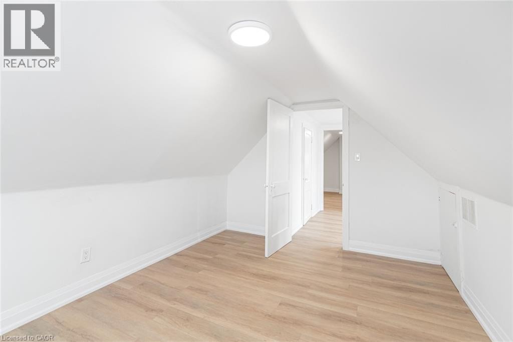 Sloped ceilings, wood-finish flooring, recessed lighting, and white panel doors - 90 Belview Avenue, Hamilton, ON
