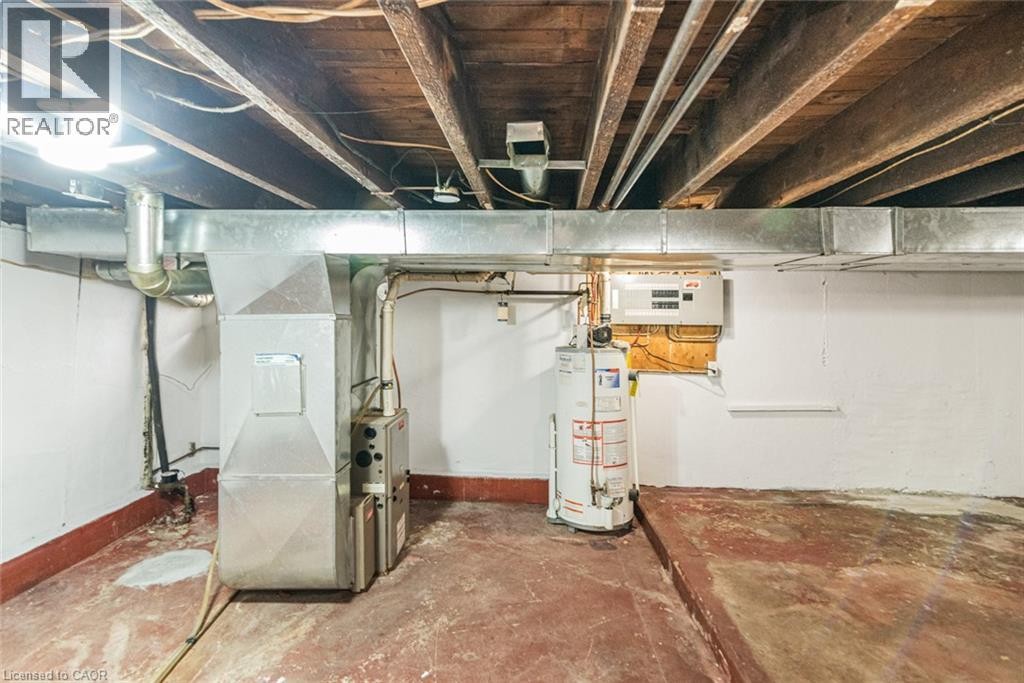 Basement utility area featuring a water heater, furnace, and exposed ceiling joists - 90 Belview Avenue, Hamilton, ON