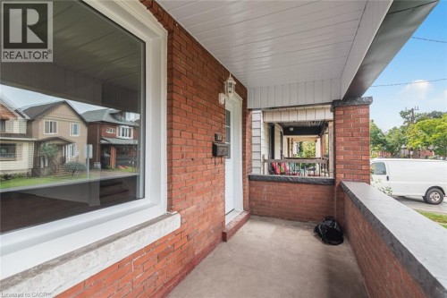 Brick exterior with white trim, concrete porch, and a white entry door - 90 Belview Avenue, Hamilton, ON 