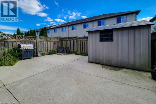 Concrete patio with wood fencing, lattice accents, and a built-in storage shed - 21 Jonathon Court, Hamilton, ON 