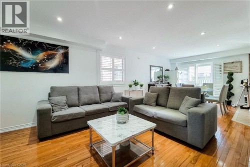 Recessed lighting illuminates the open-concept living space with wood-finish flooring - 21 Jonathon Court, Hamilton, ON 
