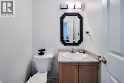 Built-in vanity with wood-finish cabinetry, integrated basin, and neutral-toned countertop - 21 Jonathon Court, Hamilton, ON 