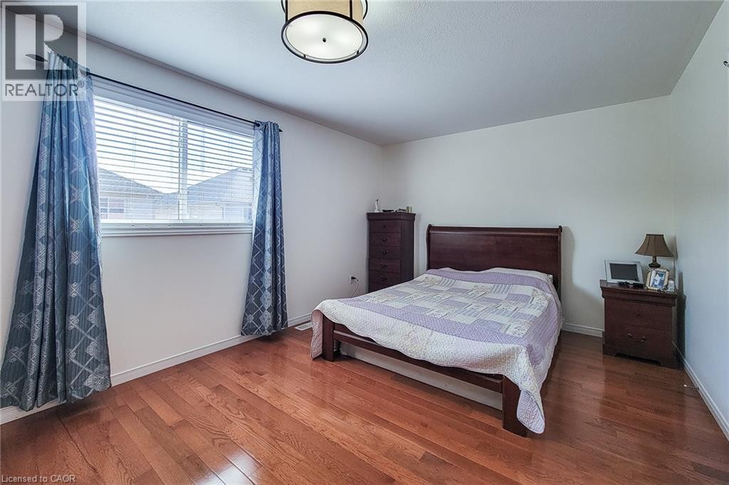 Hardwood flooring, white wall paint, window with blinds, and a semi-flush ceiling light fixture - 21 Jonathon Court, Hamilton, ON