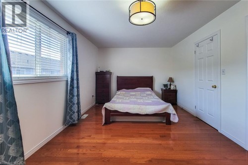 Wood-finish flooring, white walls, and a multi-paneled door - 21 Jonathon Court, Hamilton, ON 