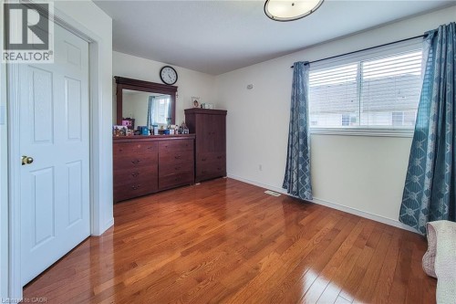 Wood-finish flooring, white walls, and a window with blinds - 21 Jonathon Court, Hamilton, ON 