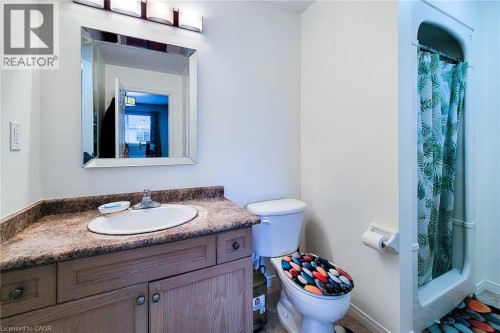 Vanity with laminate countertop, integrated sink, mirrored cabinet, and an adjacent shower stall - 21 Jonathon Court, Hamilton, ON 