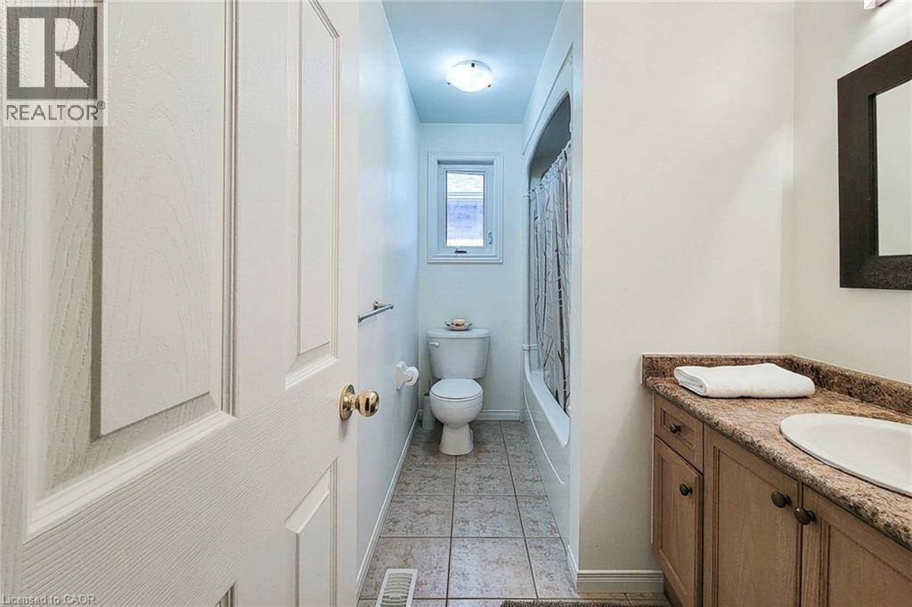 Bathroom with a vanity featuring a built-in sink, a shower-tub combination, and tiled flooring - 21 Jonathon Court, Hamilton, ON
