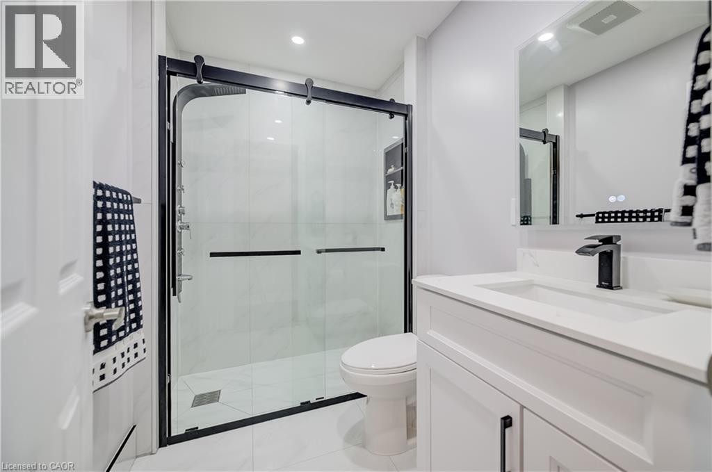 White vanity with integrated sink, black-finish faucet, and coordinating cabinet hardware - 573 Robert Ferrie Drive, Kitchener, ON