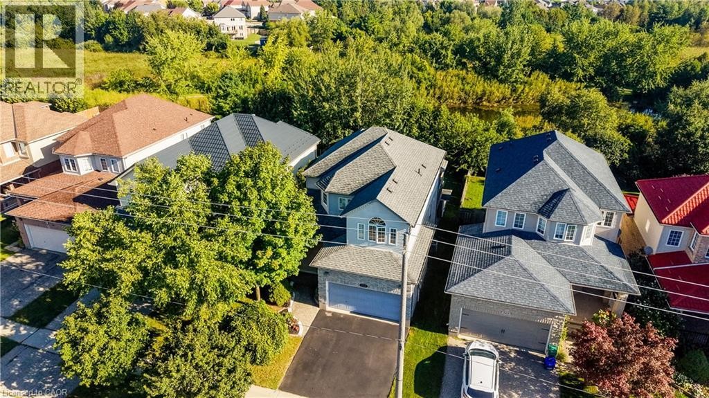 Aerial view of a residential property with a multi-level roofline, attached garage, and paved driveway - 573 Robert Ferrie Drive, Kitchener, ON