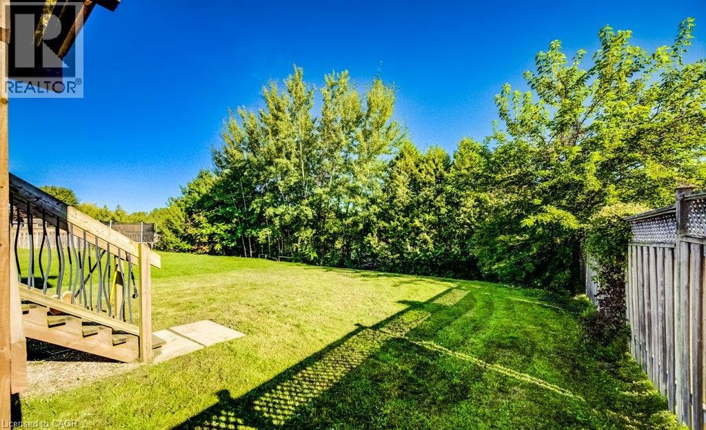 Expansive grassy yard with mature trees and wood fencing - 573 Robert Ferrie Drive, Kitchener, ON
