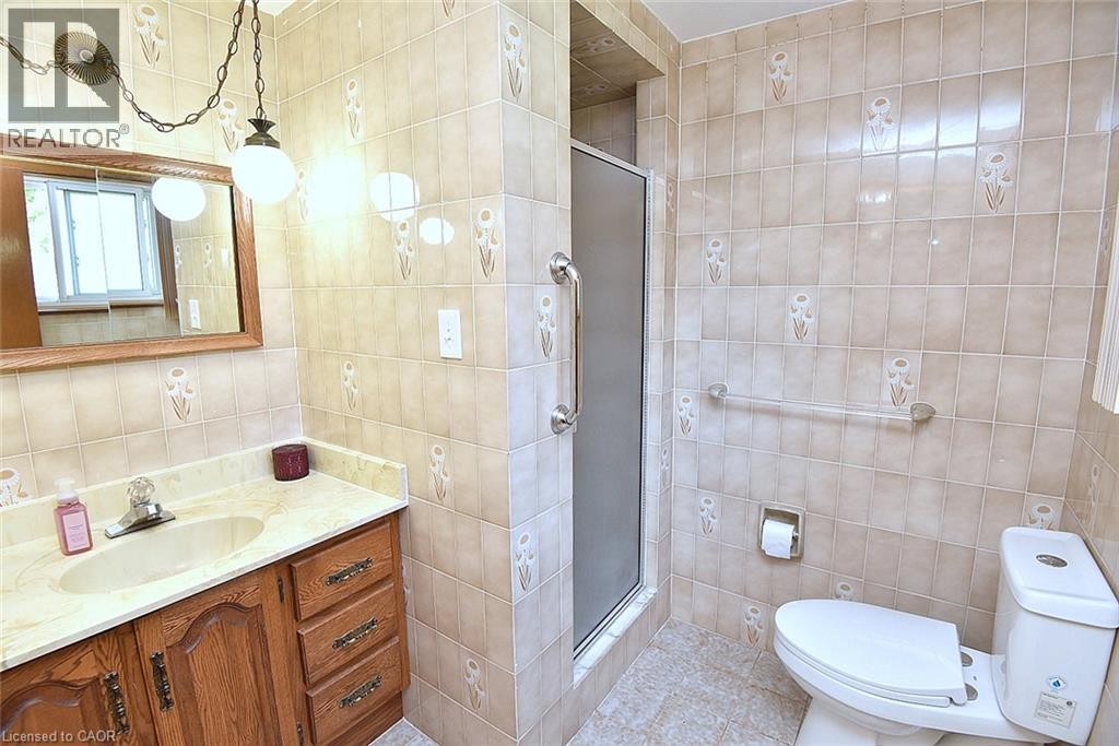 Bathroom featuring a vanity with a drop-in sink, wood-finish cabinetry, and a countertop - 372 Fennell Avenue W, Hamilton, ON