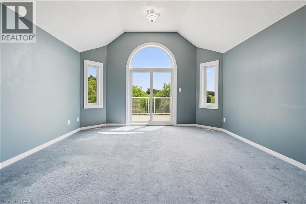 Vaulted ceiling room with an arched glass door, two rectangular windows, and a ceiling-mounted light fixture - 426 Hidden Creek Drive, Kitchener, ON