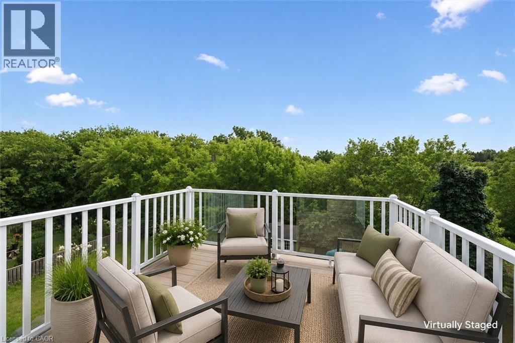 Expansive outdoor terrace featuring composite decking, white railing, and clear panel balustrade - 426 Hidden Creek Drive, Kitchener, ON