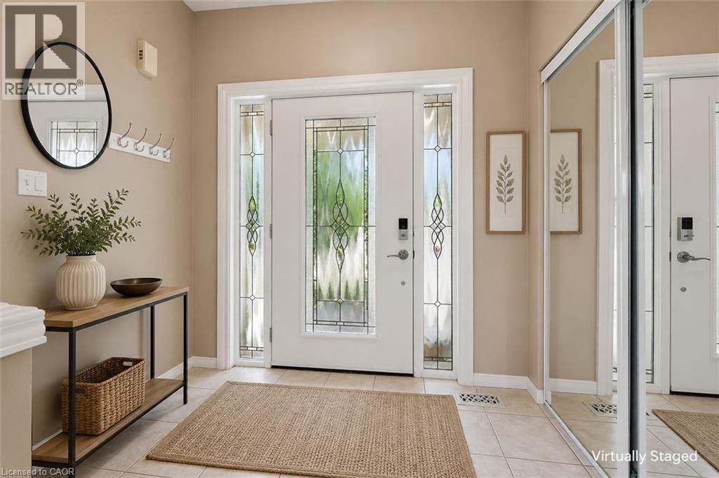 Entryway with ceramic tile flooring, a white front door featuring decorative glass, and coordinating sidelight panels - 426 Hidden Creek Drive, Kitchener, ON