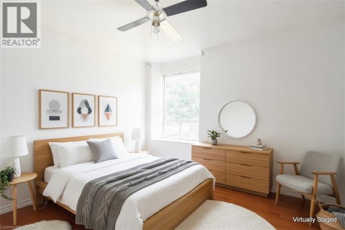 White walls, wood-finish flooring, and a ceiling fan - 355 Macnab Street N, Hamilton, ON 