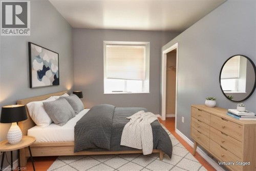 Wood-finish flooring, neutral wall tones, and a window with a roller shade - 355 Macnab Street N, Hamilton, ON 