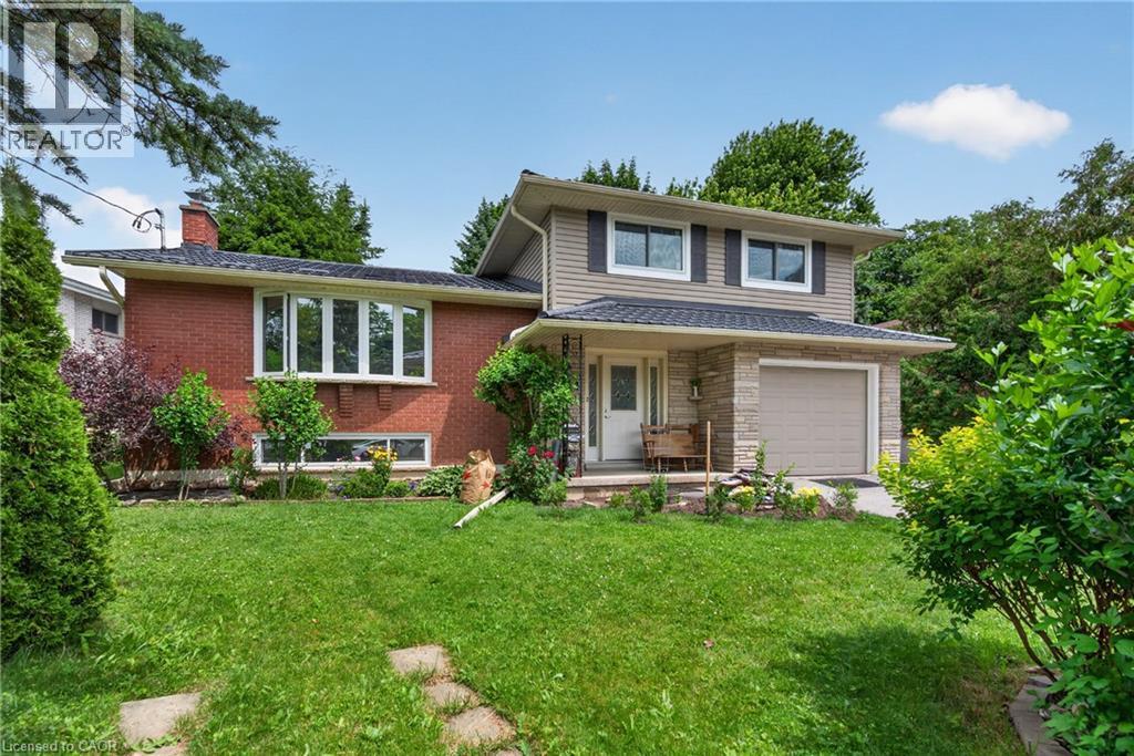 Brick and siding exterior with stone accents, bay window, attached garage, covered entryway, and front lawn - 114 Shuh Avenue, Kitchener, ON