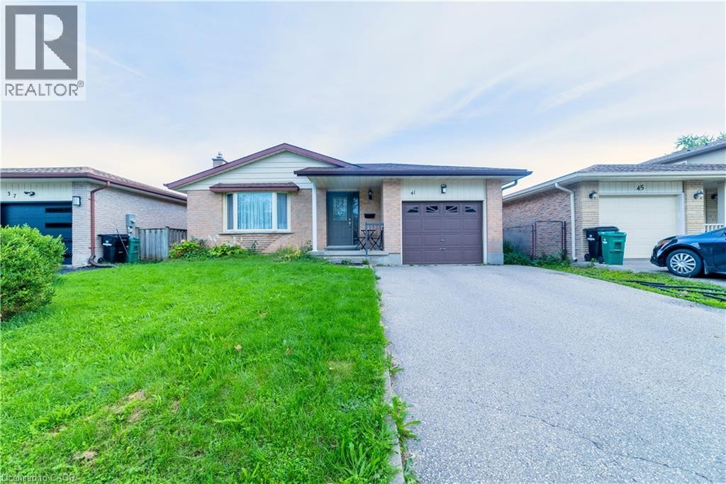 Brick facade with a contrasting front garage, paved driveway, and established front lawn - 41 Tuerr Drive, Kitchener, ON