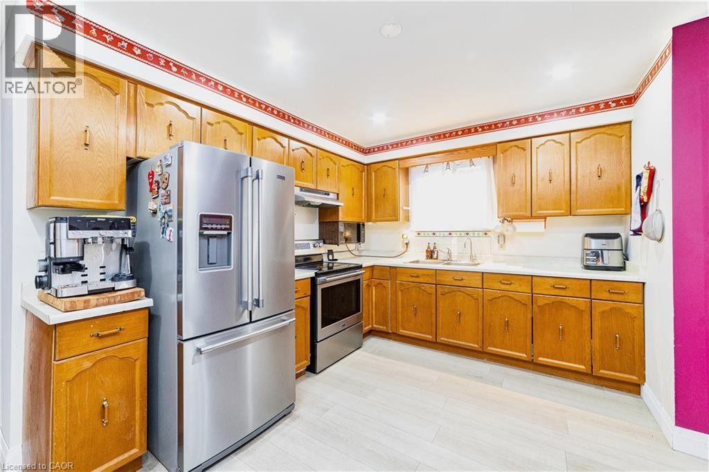 Kitchen featuring wood cabinetry, white countertops, stainless steel appliances, and light-toned flooring - 41 Tuerr Drive, Kitchener, ON