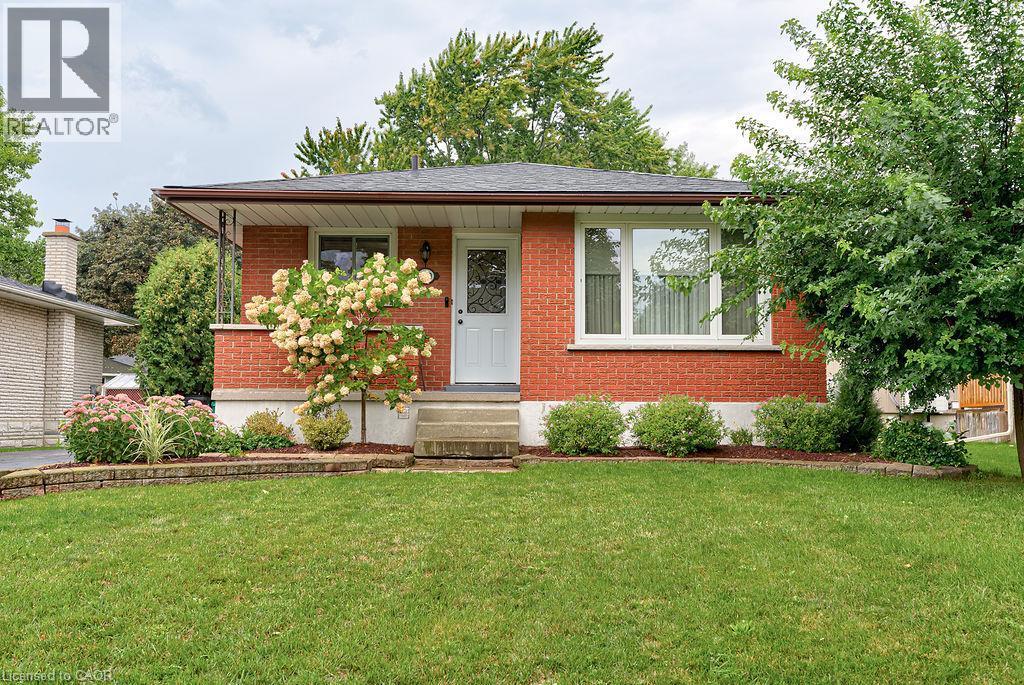 Brick exterior with a covered front porch and mature landscaping - 210 Shelley Drive, Kitchener, ON