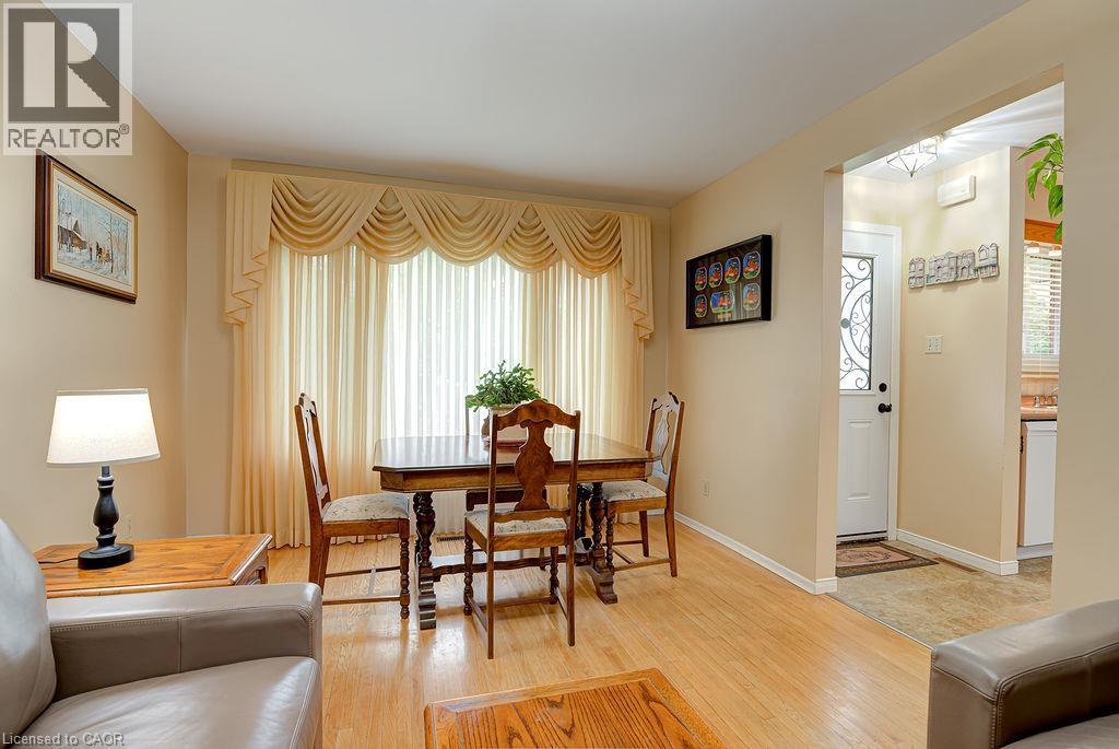 Light wood-finish flooring throughout, complemented by neutral wall tones - 210 Shelley Drive, Kitchener, ON