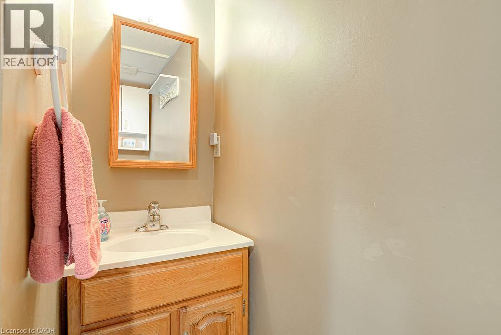 Vanity with wood-finish cabinetry, integrated sink, and chrome-finish faucet - 210 Shelley Drive, Kitchener, ON