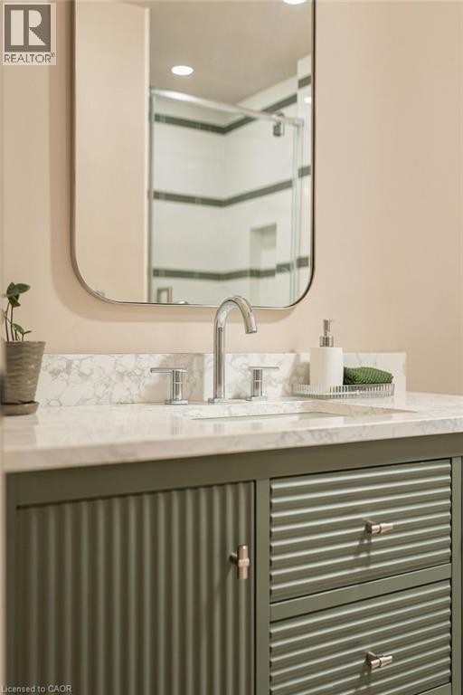 Vanity with a light-toned countertop, chrome faucet, and integrated sink - 571 Leonard Court, Burlington, ON