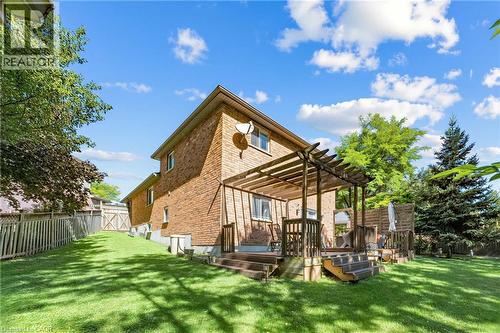 Brick exterior, multi-level wood deck with pergola, extensive grass yard, and mature perimeter trees - 125 Langlaw Drive, Cambridge, ON 