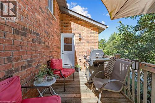 Wood deck with a brick exterior, white exterior door, and wood railing - 125 Langlaw Drive, Cambridge, ON 