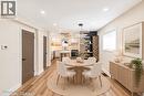 Wood-finish flooring throughout, recessed ceiling lighting, and a kitchen with white cabinetry - 250 Rosslyn Avenue N, Hamilton, ON 