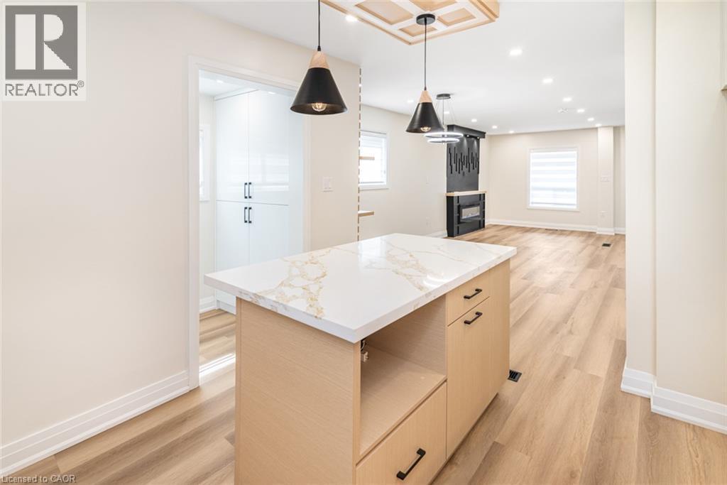 Kitchen island with a light wood finish and a white countertop, featuring integrated storage - 250 Rosslyn Avenue N, Hamilton, ON