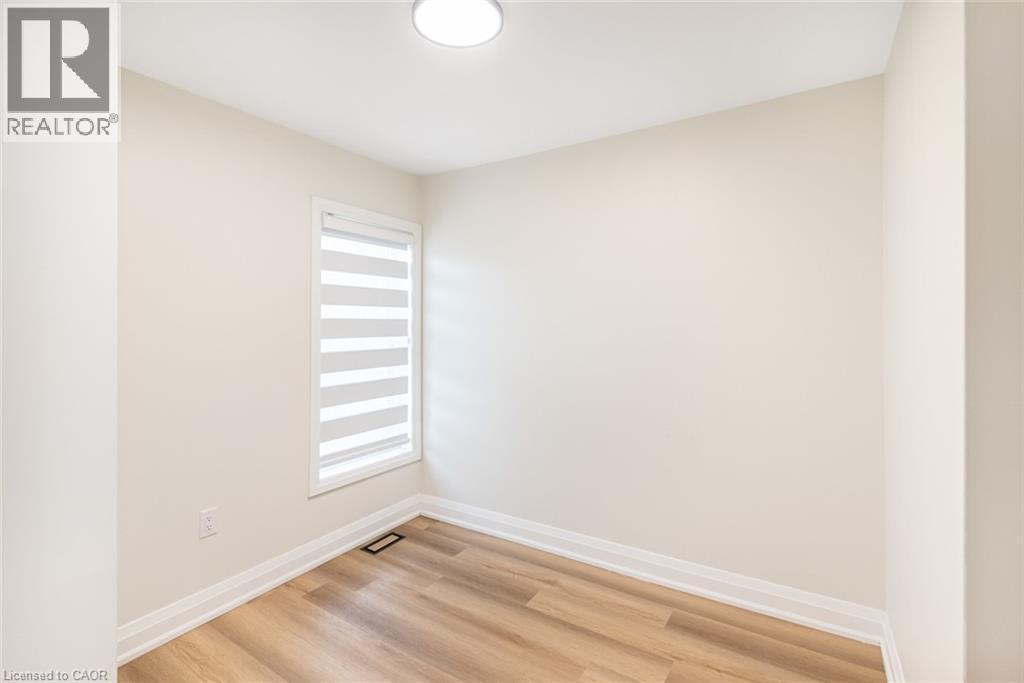 Wood-finish flooring, neutral wall paint, window with horizontal blinds, flush mount ceiling light - 250 Rosslyn Avenue N, Hamilton, ON