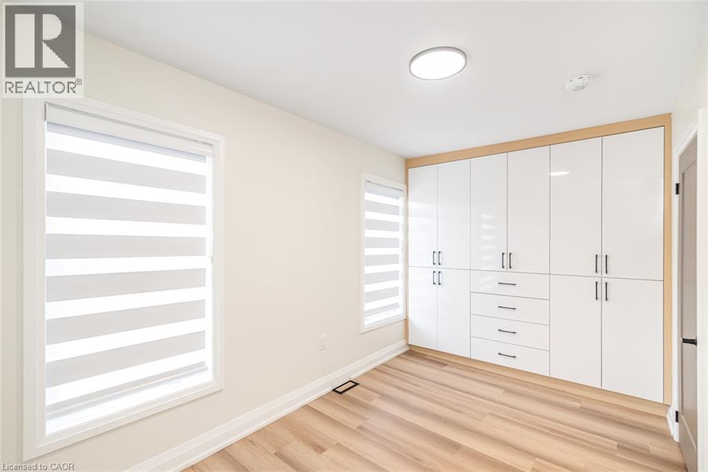 Built-in white high-gloss cabinetry with integrated drawers and matte black hardware - 250 Rosslyn Avenue N, Hamilton, ON