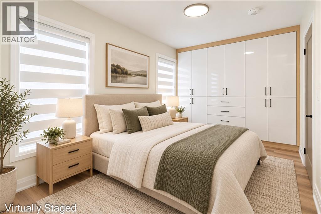 Integrated white gloss cabinetry with wood-finish trim, two large windows with horizontal blinds, and wood-finish flooring - 250 Rosslyn Avenue N, Hamilton, ON