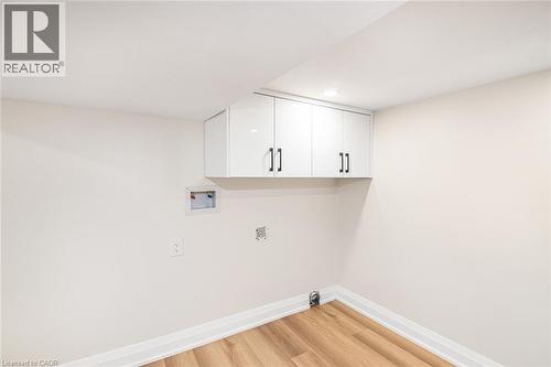 White shaker-style cabinetry with black hardware, recessed lighting, wood-finish flooring, and white baseboards - 250 Rosslyn Avenue N, Hamilton, ON 