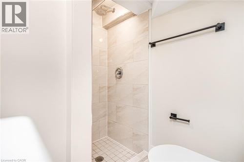 Walk-in shower with tiled walls and floor, complete with a rain shower head and a hand-held shower fixture - 250 Rosslyn Avenue N, Hamilton, ON 