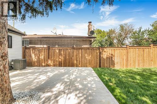 Expansive concrete patio with a manicured lawn and privacy fencing - 250 Rosslyn Avenue N, Hamilton, ON 