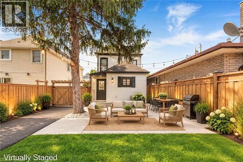 Expansive outdoor living area featuring a paved patio, manicured lawn, and mature trees - 250 Rosslyn Avenue N, Hamilton, ON 