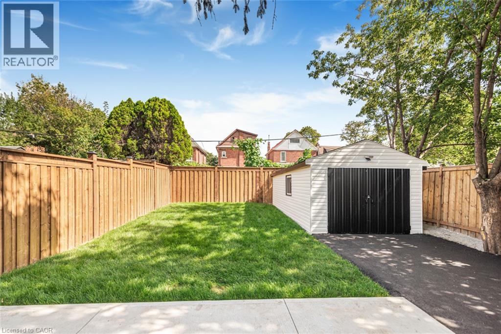 Detached garage with black doors and asphalt driveway - 250 Rosslyn Avenue N, Hamilton, ON