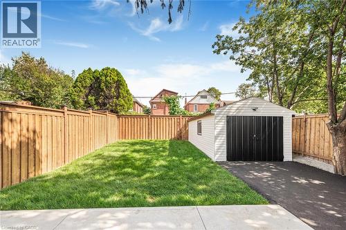 Detached garage with black doors and asphalt driveway - 250 Rosslyn Avenue N, Hamilton, ON 