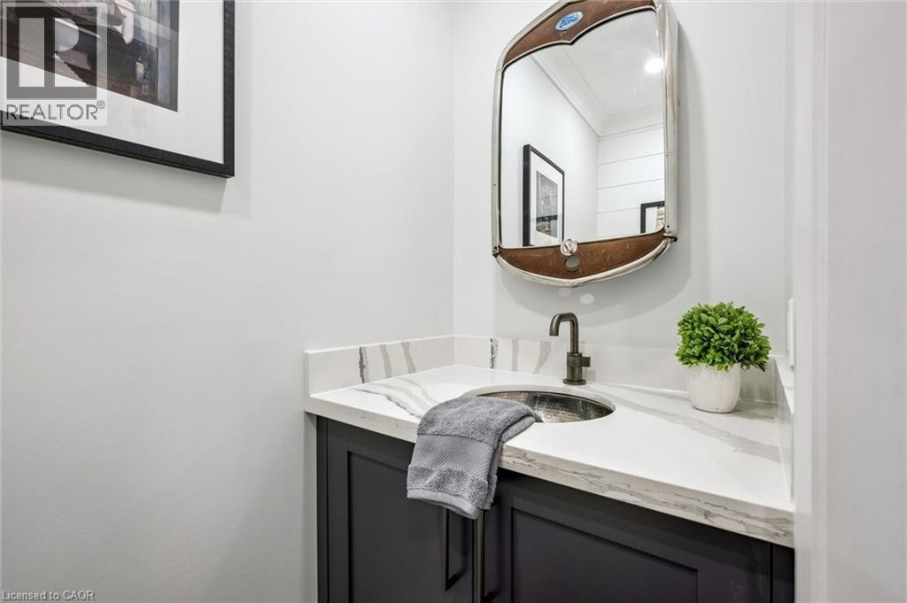 Vanity with dark cabinetry, white countertop, and an undermount basin - 1261 Stephenson Drive, Burlington, ON