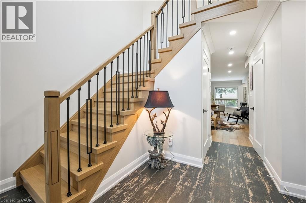 Hardwood staircase with black metal balusters and a wood-finish handrail - 1261 Stephenson Drive, Burlington, ON