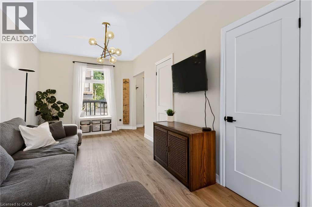 Recessed lighting, contemporary chandelier, wood-finish flooring, white paneled doors with black hardware - 34 Baillie Street, Hamilton, ON