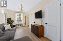 Recessed lighting, contemporary chandelier, wood-finish flooring, white paneled doors with black hardware - 34 Baillie Street, Hamilton, ON 