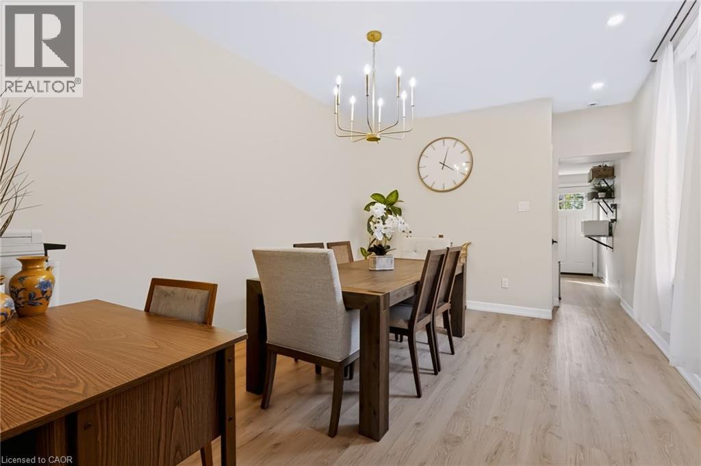Vaulted ceiling, gold-finish chandelier, recessed lighting, wood-finish flooring, and white walls - 34 Baillie Street, Hamilton, ON